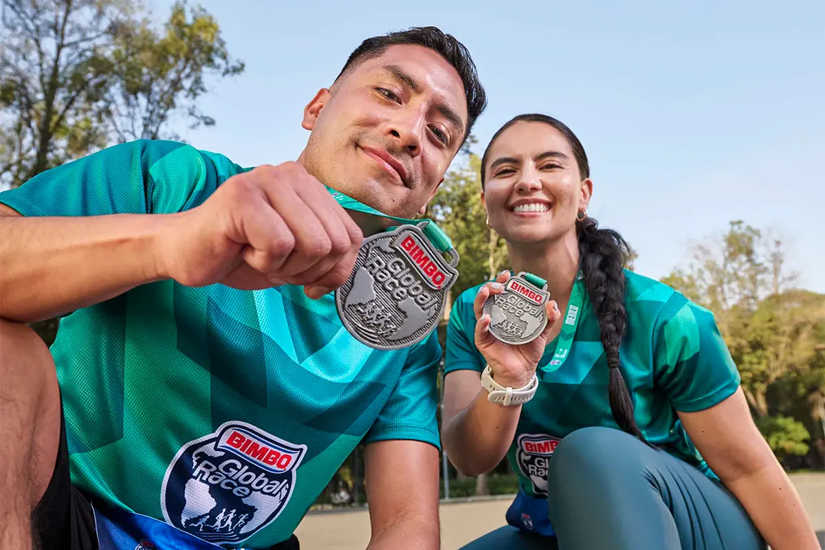 participantes posando con la medalla de la carrera Bimbo Global Race