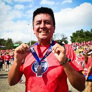 Corredor mostrando la medalla al finalizar la carrera