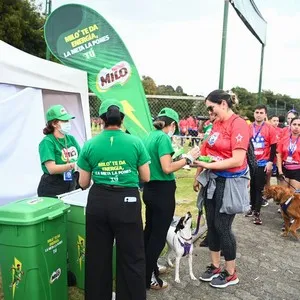 Participantes visitando el stand de Milo