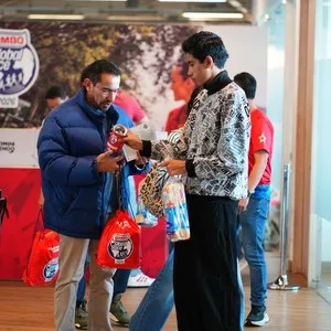 Asistentes recogiendo su kit de participante en la Bimbo Global Race 2026