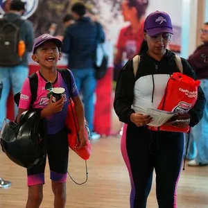 Grupos de corredores compartiendo con otros participantes en la entrega de kits en la Bimbo Global Race 2026